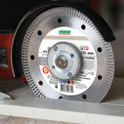 Installer cutting porcelain gres tile with DISTAR Multigres blade on angle grinder