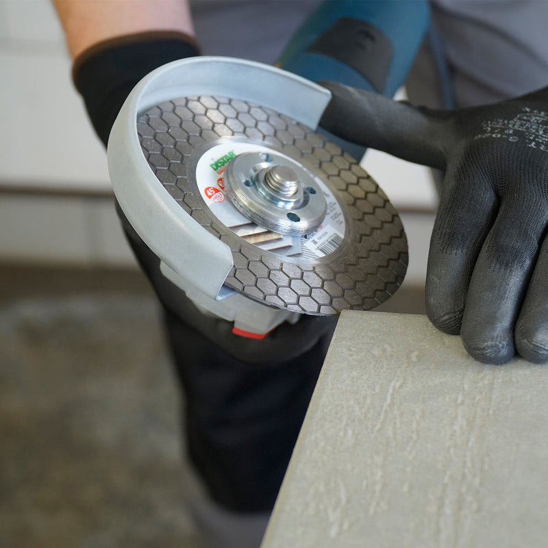 Tiler cutting porcelain tile at 45 degree bevel with DISTAR Edge Dry diamond blade