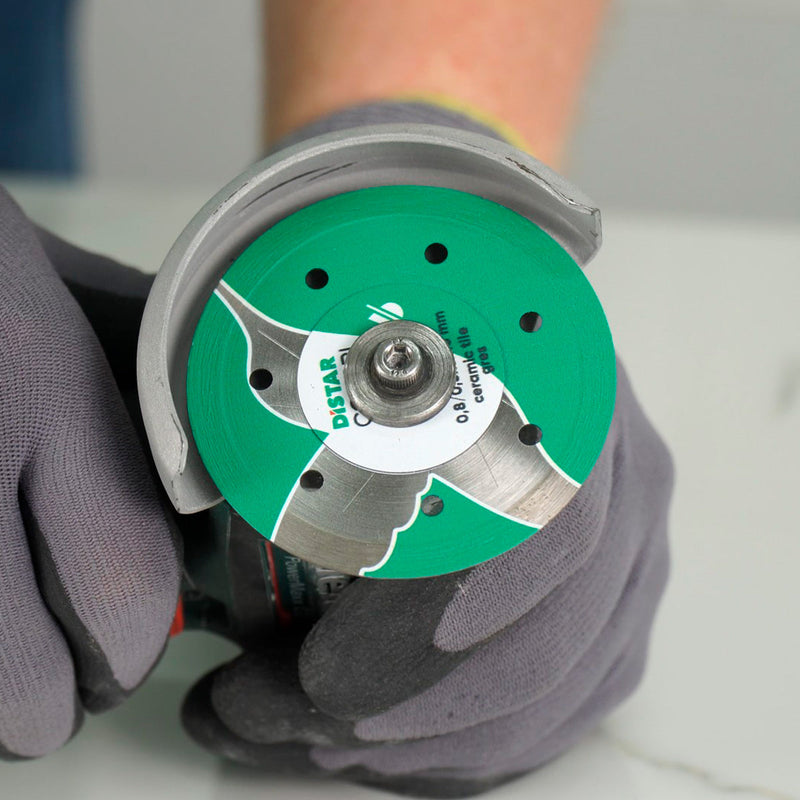 Installer using Colibri 3 inch diamond blade on cordless grinder for detailed porcelain cut