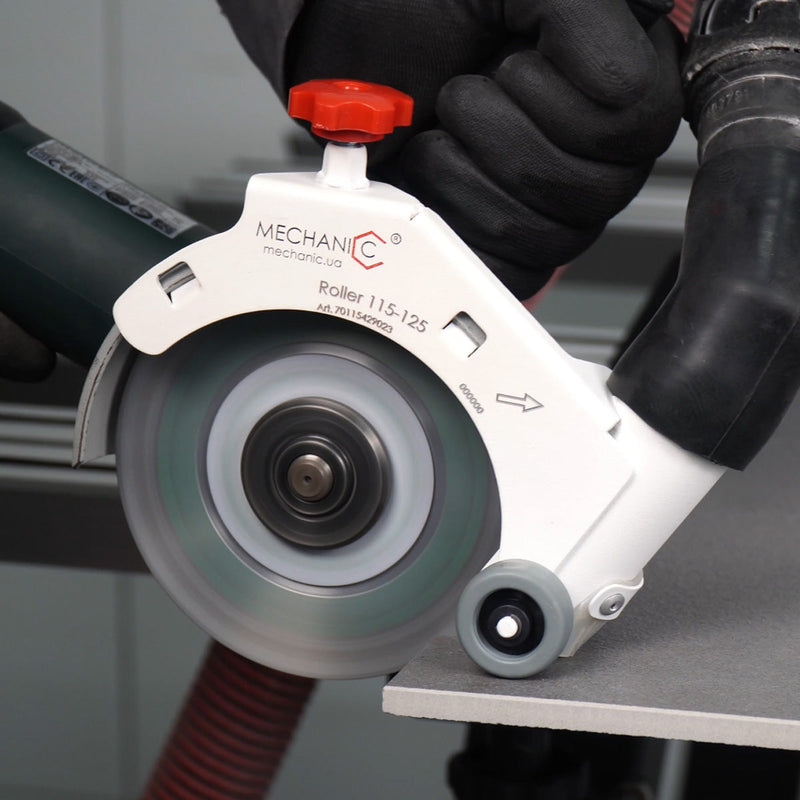 Mechanic roller tool with a red handle being used on a gray surface.