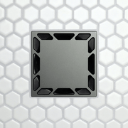 Square drain grate with corner notch openings, dark metal faceplate.