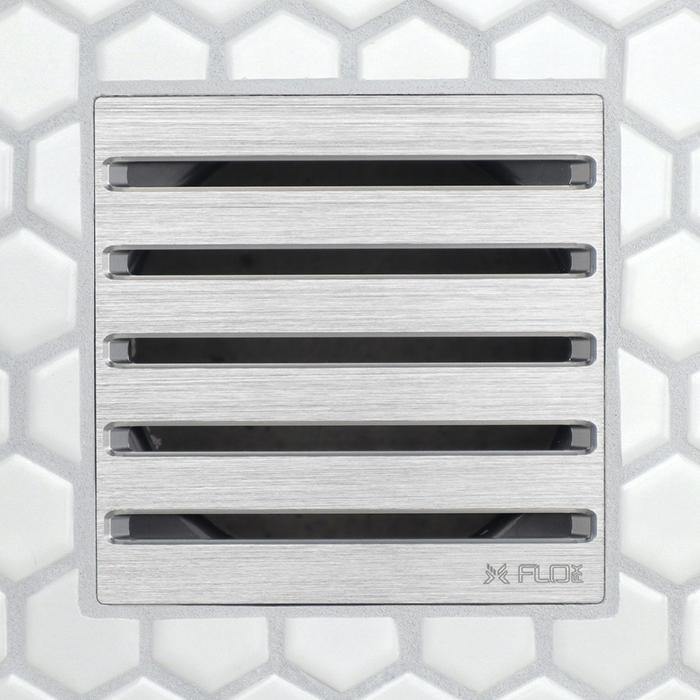 Brushed metal square drain grate with four long horizontal openings and dark inserts