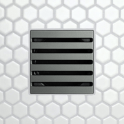 Drain grate with five long horizontal slots, dark matte finish.