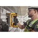 Contractor using Dewalt 20V MAX GRABO Lifter to install a large piece of glass on a wall
