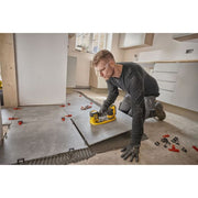 Contractor using Dewalt 20V MAX GRABO Lifter to install a large floor tile on site