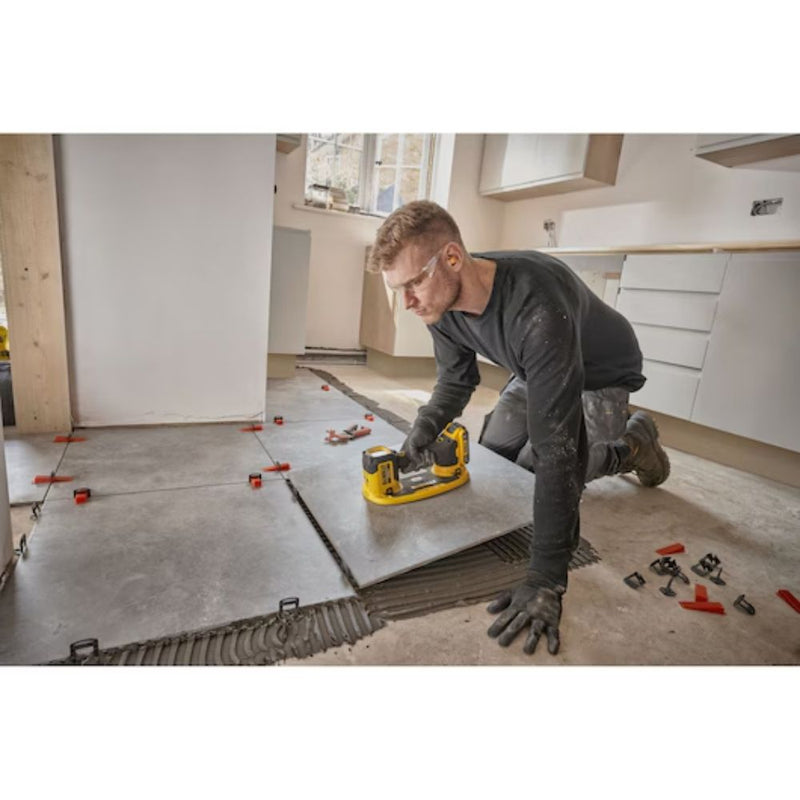 Contractor using Dewalt 20V MAX GRABO Lifter to install a large floor tile on site