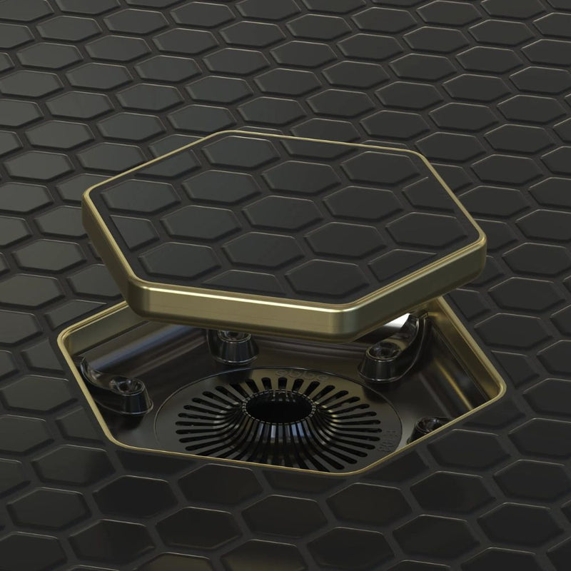 Tile-in hex drain opening with champagne gold frame and dark hex insert