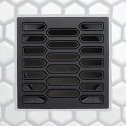 Matte black drain grate with repeating rounded rectangular slots and central elongated channel