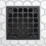 Dark charcoal drain grate with grid of rounded rectangular slots and raised border frame