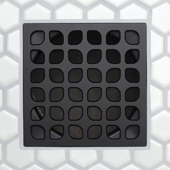 Dark charcoal drain grate with grid of rounded rectangular slots and raised border frame