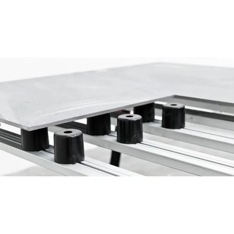 Black cylinder supports with top hole, placed along a tile leveling rail