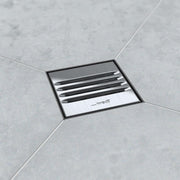 Stainless slotted square shower drain in a tiled bathroom setting