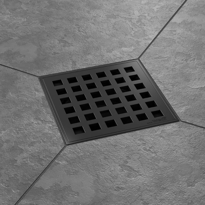 Matte Black square floor drain cover on a gray tiled floor