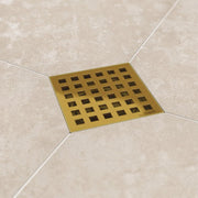 Brass square drain cover on a tiled floor