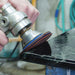 Worker using a Ceramica EX pad on a wet polisher to polish the edge of a bullnose